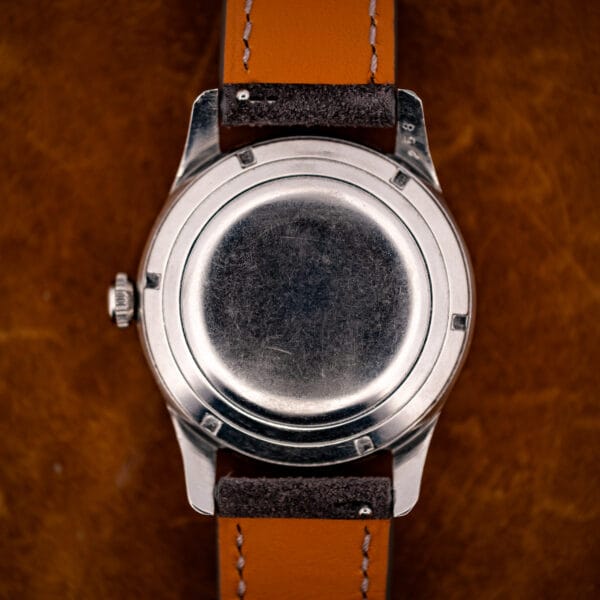 Longines 6536-1 stainless steel snap caseback exterior with honest scratches and vintage suede strap reverse