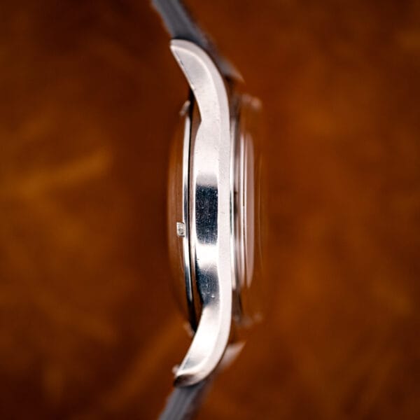 Vintage Longines bombe case side view with steeply downturned lugs and high domed crystal in stainless steel