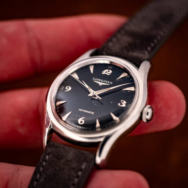 Longines 19AS automatic in hand, domed crystal catching light over the ornate black dial and dauphine hands