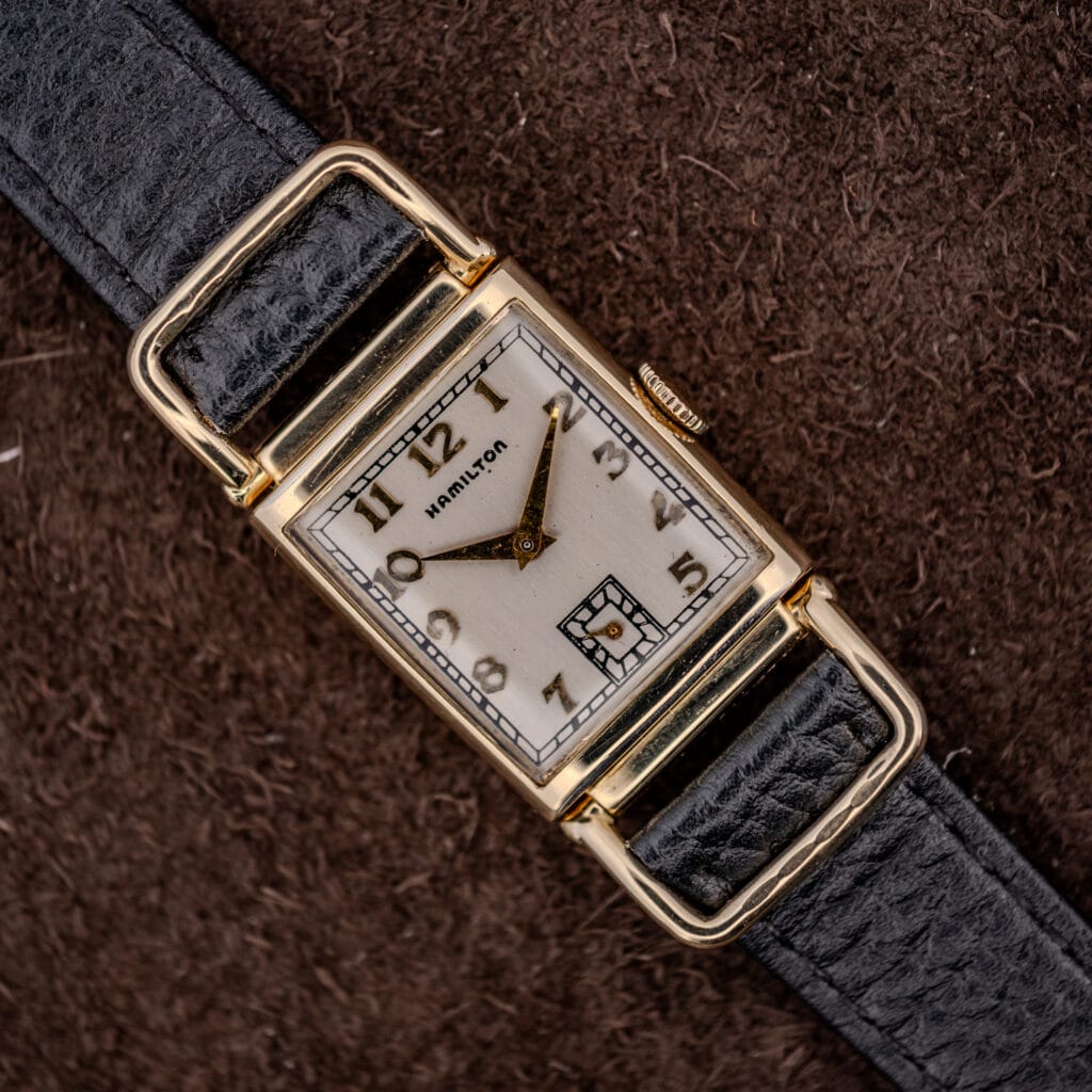 Hamilton Wilshire 14k gold filled driver's watch, silvered Art Deco dial and looping flexible lugs on a black strap