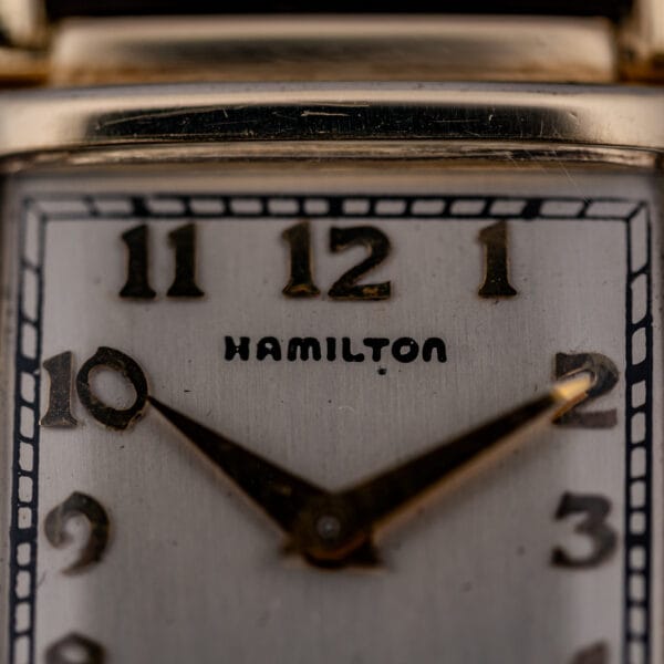 Hamilton Wilshire dial close-up with applied gold Arabic numerals and the printed HAMILTON signature below twelve