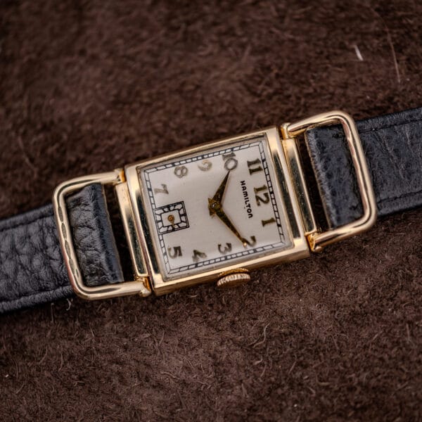 Hamilton Wilshire driver's watch from the crown side, flexible hinged lugs cradling the black leather strap