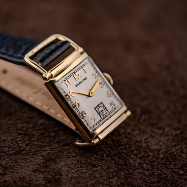 Hamilton Wilshire three-quarter view with the black buffalo-grain leather strap and plain gold-tone buckle