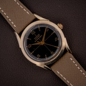 Vintage Tissot bumper automatic black gilt cross-hair dial with gold Arabic numerals on a mud grey leather strap