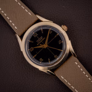 Vintage Tissot bumper automatic black gilt cross-hair dial with gold Arabic numerals on a mud grey leather strap