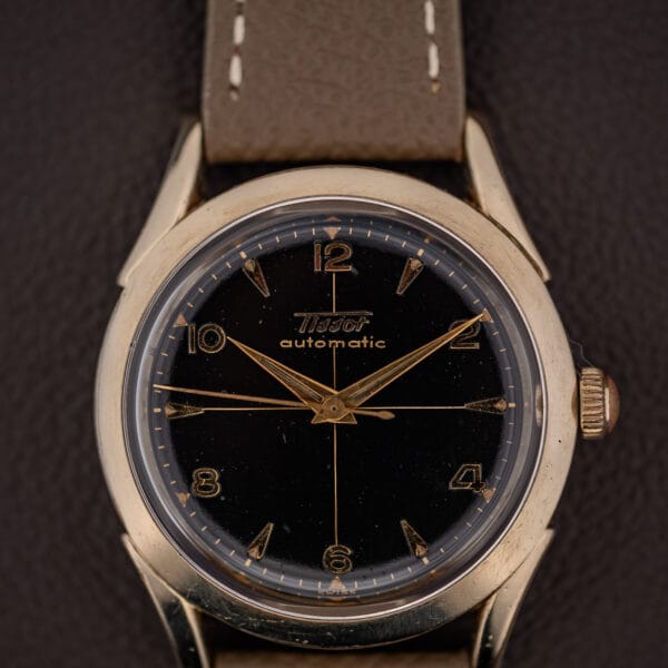 Tissot Automatic black gilt dial, gilt cross-hair center, gold dauphine hands and applied numerals, SWISS at six