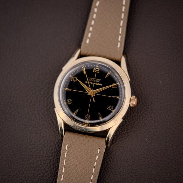 Vintage Tissot automatic 28.5-21 glossy black gilt dial and gold-filled case on a grey leather strap
