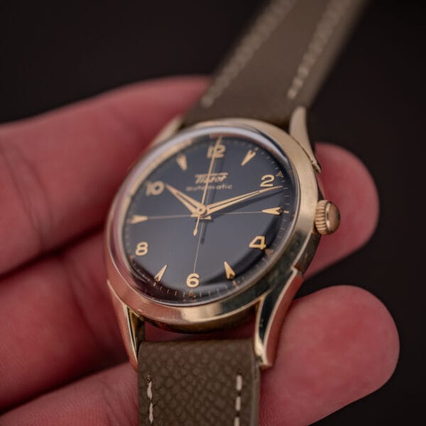 Tissot Automatic in hand, gold-filled case and black gilt cross-hair dial with gold arrowhead markers