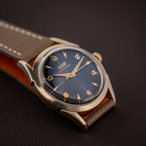 Tissot bumper automatic dial and tapered lugs, mud grey strap with tan leather underside visible