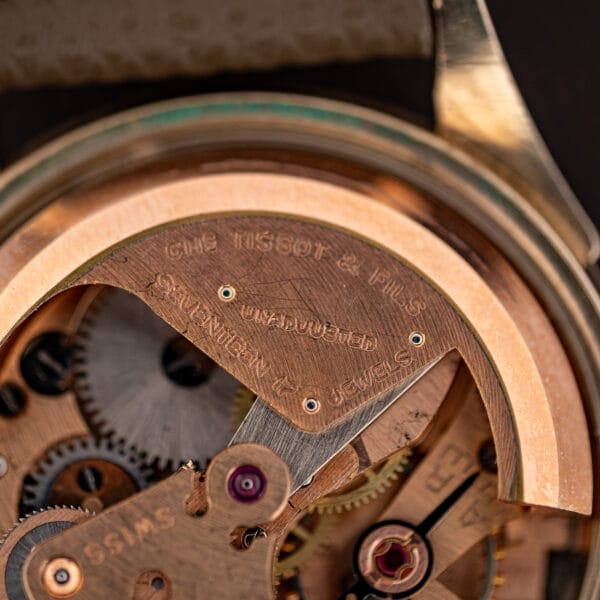 Macro of Tissot 28.5-21 movement engraving CHS TISSOT & FILS UNADJUSTED SEVENTEEN 17 JEWELS in rose gilt