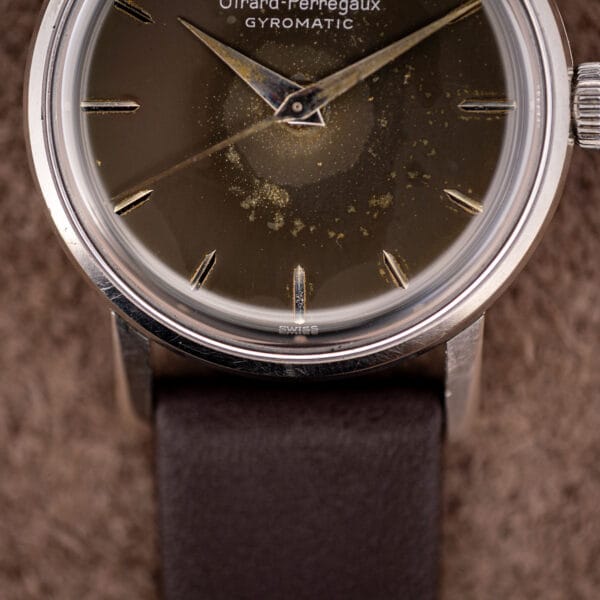 Girard-Perregaux Gyromatic dial foot reading SWISS, foxed brown-olive patina under raking light