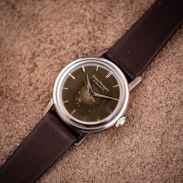 Vintage Girard-Perregaux Gyromatic stainless steel case at an angle, fluted crown and domed acrylic crystal