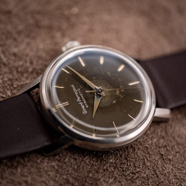 Vintage Girard-Perregaux Gyromatic brown dial turning deep olive in raking light with center seconds
