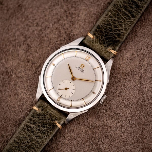 Vintage Omega automatic bumper 2421/4 angled on olive leather strap showing stainless case and sector dial