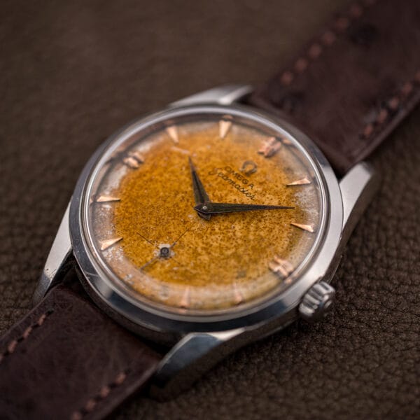 Omega Seamaster 2937-5 speckled amber tropical dial and patinated dauphine hands, three-quarter view on brown ostrich leather