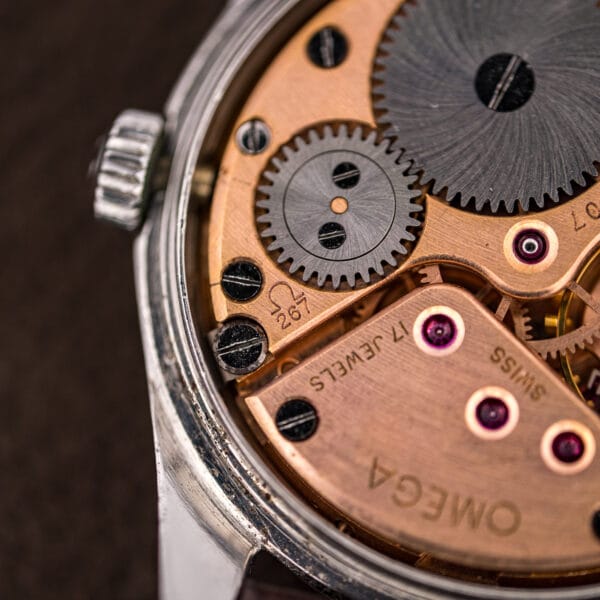 Omega caliber 267 bridge macro showing the Omega symbol, 267 and 17 JEWELS over rose-gilt plates