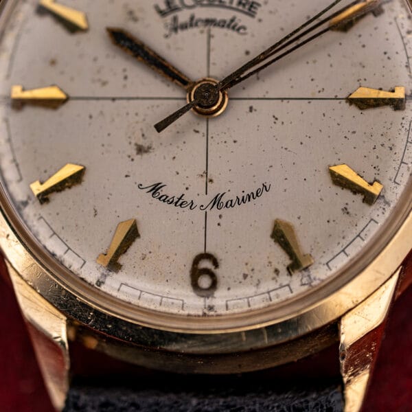 Close-up of LeCoultre Master Mariner script and applied 6 numeral with dauphine hands holding aged charcoal luminous fill