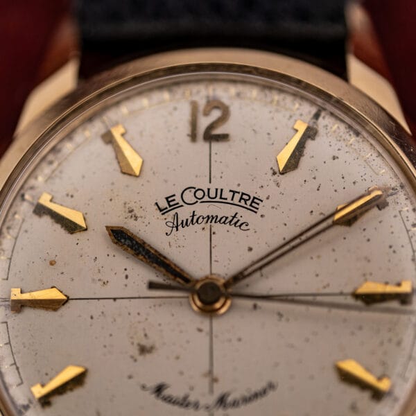 Macro of LeCoultre Master Mariner cream dial showing speckled patina, the LeCoultre Automatic logo and an applied gold 12 numeral