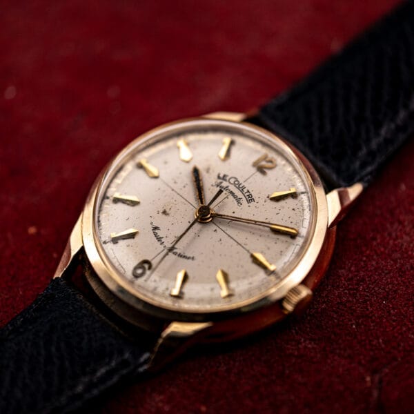 Vintage LeCoultre Master Mariner 14k gold case at an angle, domed crystal and faceted lugs on a black leather strap