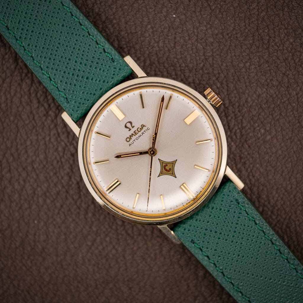 Vintage Omega Automatic ref. 14765 silver dial with applied gold batons and red-C logo cartouche on pine green strap