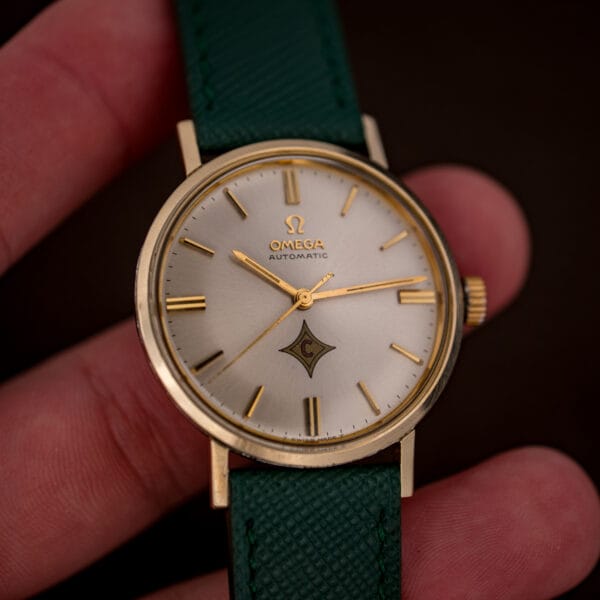Vintage Omega Automatic ref. 14765 held in hand, silver dial with red-C logo cartouche and no date window