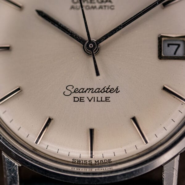 Close-up of the Omega Seamaster De Ville dial signature, Seamaster in cursive above De Ville in block capitals.