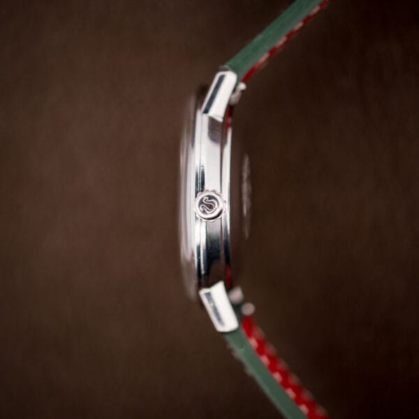 Side profile of the Omega Seamaster De Ville showing the signed Omega crown and polished stainless steel case.