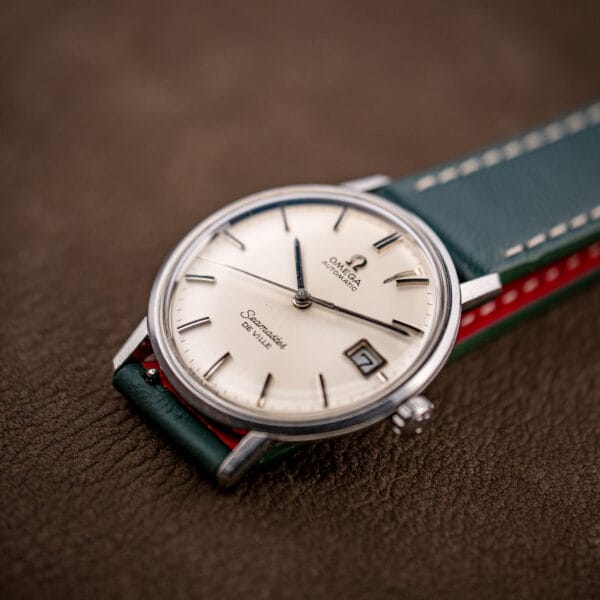 Omega Seamaster De Ville silver dial with Swiss Made printing at six and a framed date window at three o'clock.