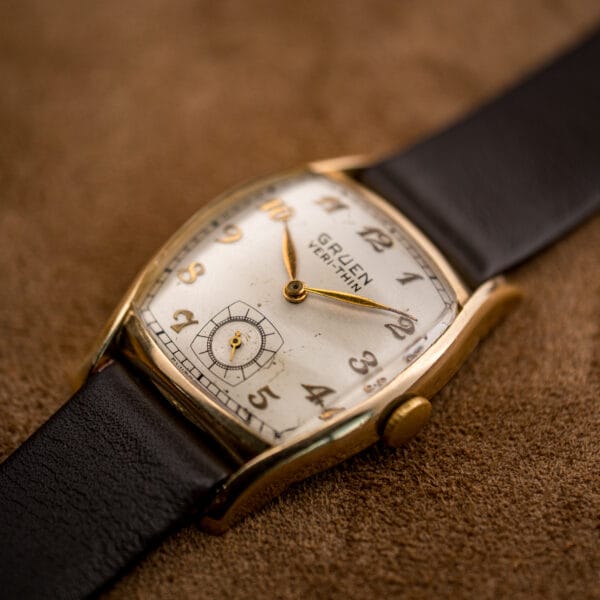 Gruen Veri-Thin ref 421-653 gold filled tonneau case angled on tan suede catching warm light
