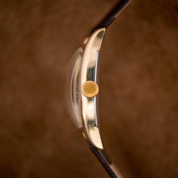 Side profile of the Gruen Veri-Thin showing the high-domed crystal and gold-tone winding crown at three