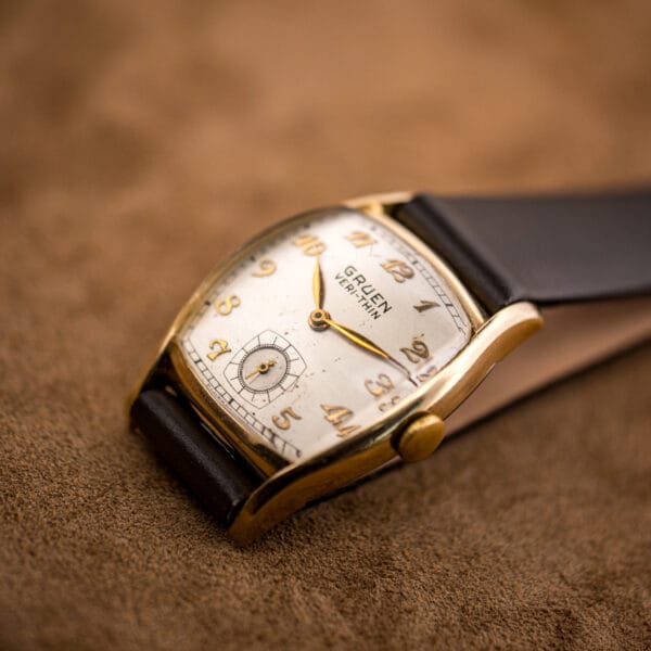 Gruen Veri-Thin 421-653 gold filled tonneau case resting on tan suede with cream gilt Arabic dial