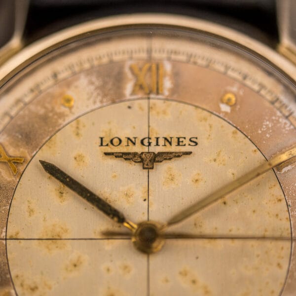 Longines Ref. 2030 dial detail with the printed LONGINES name, winged-hourglass logo and applied XII above freckled toning