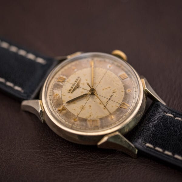 Longines Ref. 2030 dress watch at three-quarter angle, faceted horned lugs and warm cross-hair dial on black leather