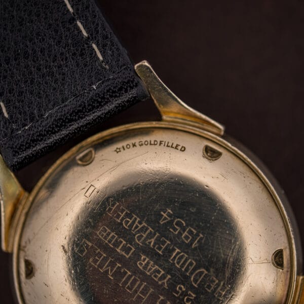 Longines Ref. 2030 side profile showing the gold-filled case flank, domed crystal and tapered faceted lugs
