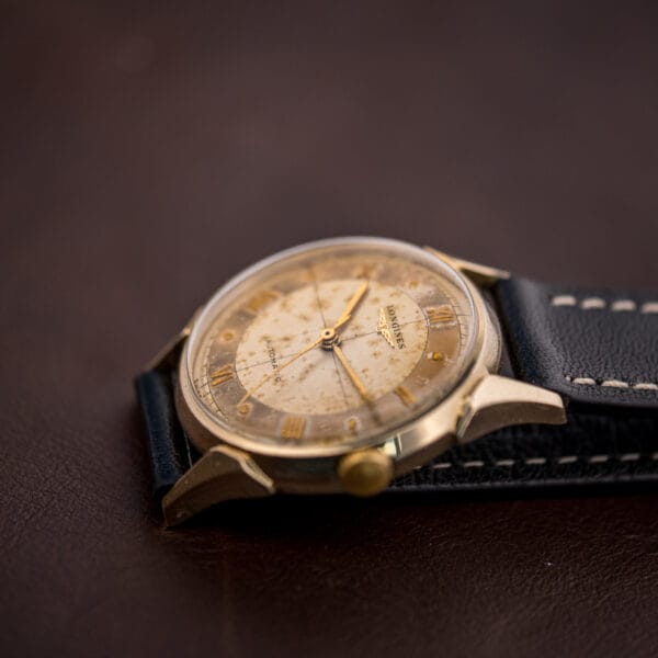 Vintage Longines 2030 on a black leather strap, warm tropical cross-hair dial and ribbed gold winding crown