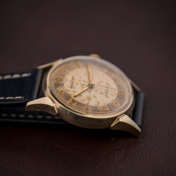 Longines Automatic Ref. 2030 angled on black leather, foxed champagne dial with the segmented cross-hair