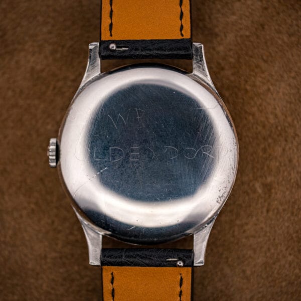 Omega Jumbo ref. 2256/1 tilted to show curved lugs, signed crown and a freckled eggshell dial