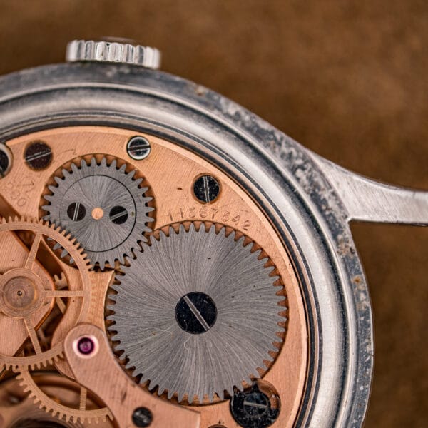 Omega 2256/1 movement macro showing the serial number 11567542 stamped on the rose-gilt mainplate