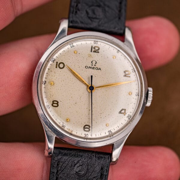 Front view of the Omega 2256/1 Jumbo in hand with blued central seconds and gilt Arabic numerals on a foxed dial