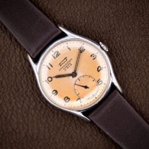 Vintage Tissot Antimagnetique ref. 6439-2 with eggshell dial faded to warm salmon, showing the Barth Zurich retailer signature.