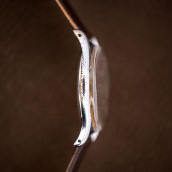 Case-band profile of the vintage Tissot Antimagnetique with chrome worn to brass along the high points.