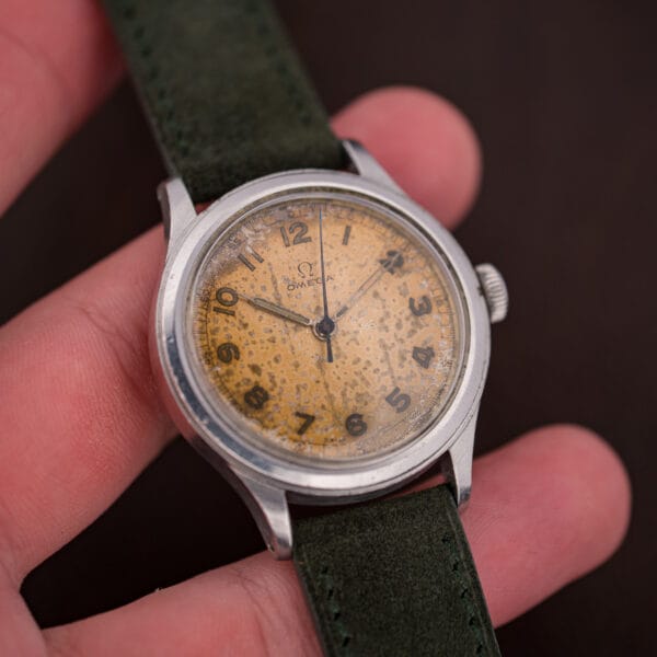 Vintage Omega Ref. 2179/4 in hand showing its 35.5mm steel case and green suede strap