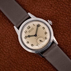 Vintage Gruen Precision Autowind on a brown leather strap, off-white luminous Arabic dial facing forward.