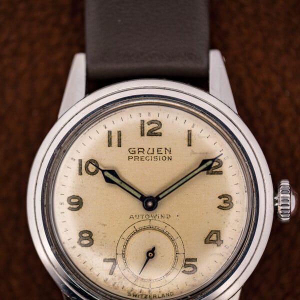 Gruen Precision Autowind dial close-up: luminous Arabic numerals, sub-seconds at six, and blued dauphine hands.