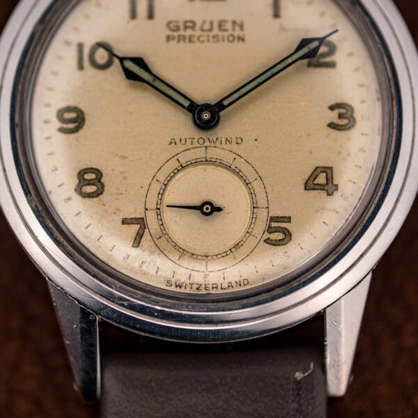 Macro of the Gruen dial showing the Precision and Autowind signatures and aged cream luminous numerals.