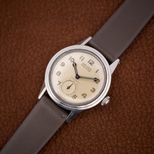 Angled view of the vintage Gruen Autowind on a brown leather strap, its domed crystal catching warm light over the dial.