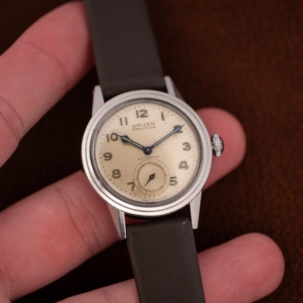 Vintage Gruen Precision Autowind held in hand, its luminous field-style dial and blued hands in daylight.