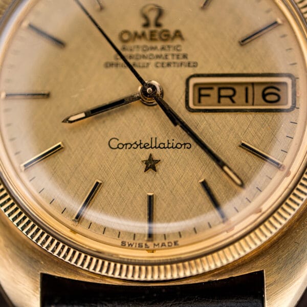Close-up of the champagne linen dial with applied baton markers, Constellation script, and the gold observatory star above six o'clock.