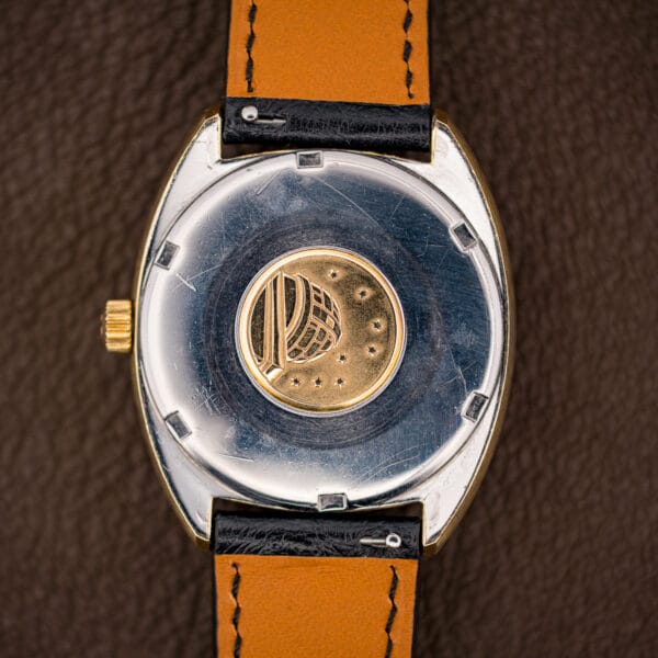 Stainless steel Omega caseback stamped with the observatory medallion, a domed observatory beneath eight stars marking the Constellation line.