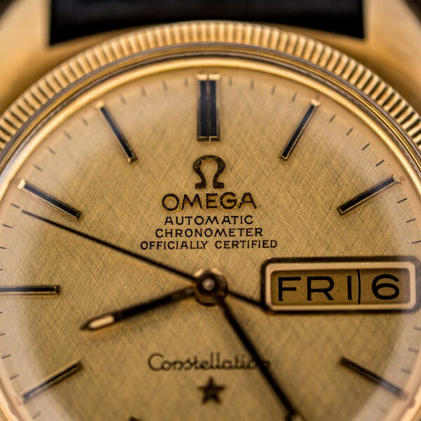 Omega Constellation Ref. 168.023 tilted to catch light across the linen dial, day-date window, and fluted gold bezel.